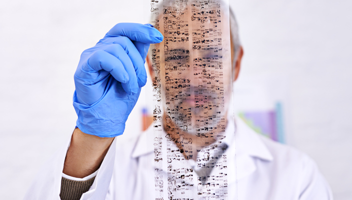 A scientist holding a transparency with the results of a DNA test