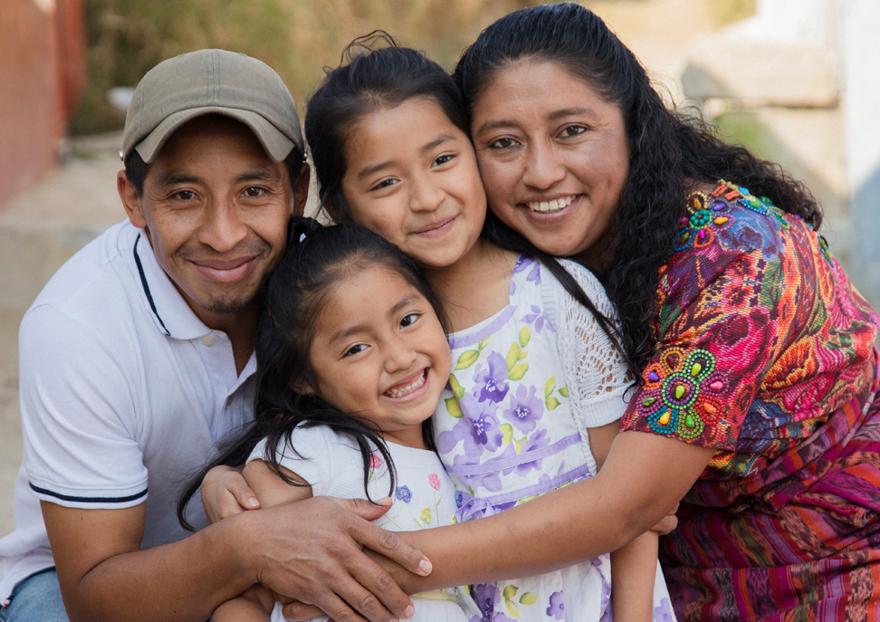A Latino family of two adults and two children. 