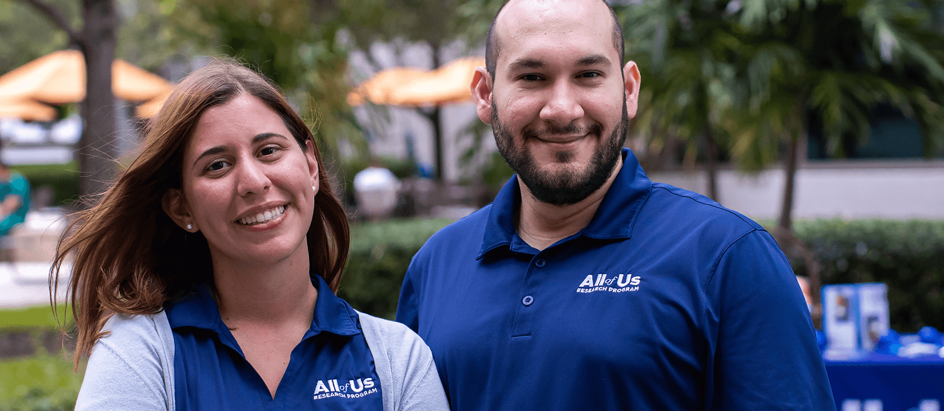 Two volunteers wearing All of Us shirts.