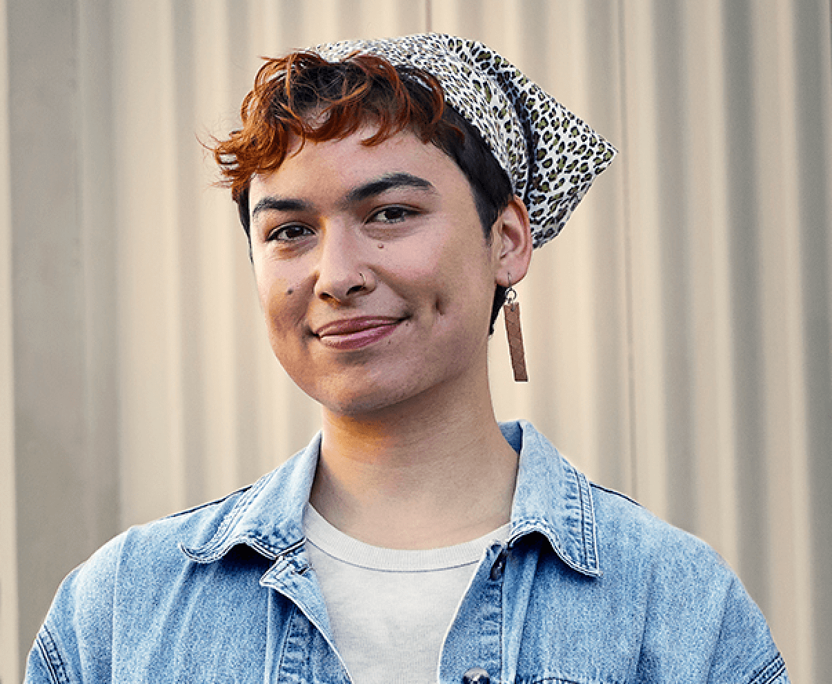 A young person in a denim jacket and a bandana.